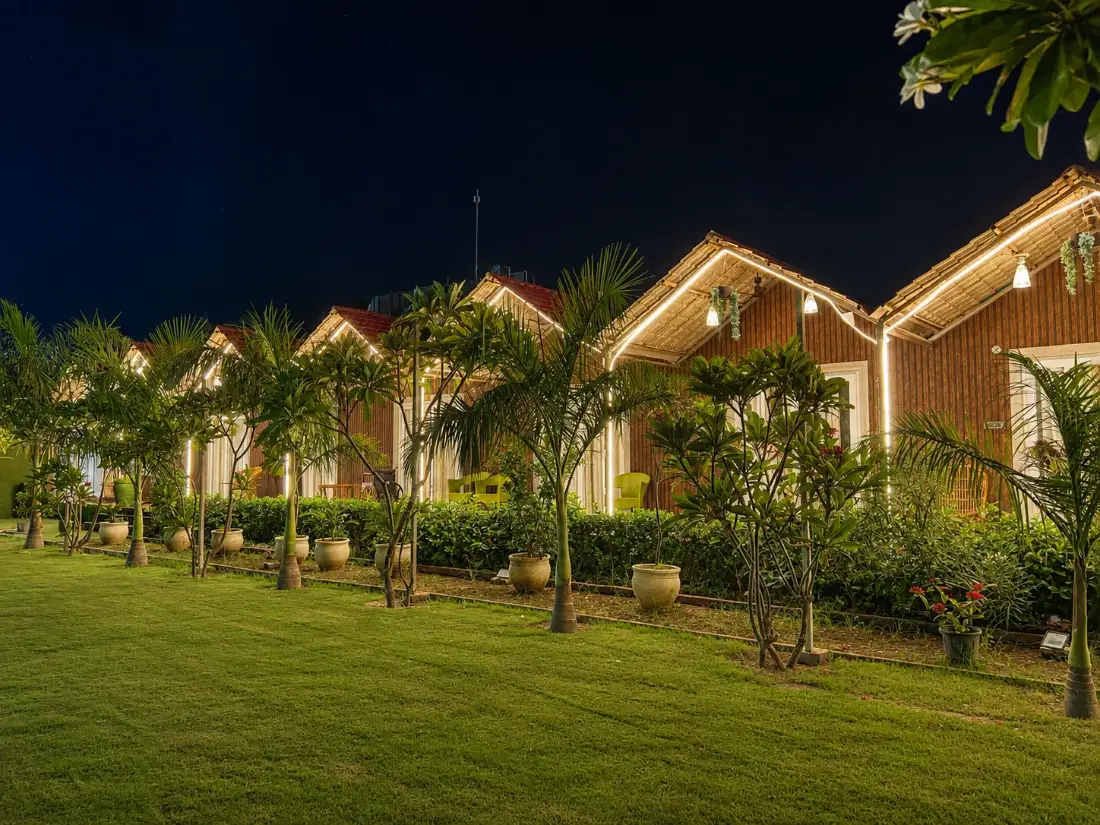 Cottages lit up at night at Chandrika Green Resort